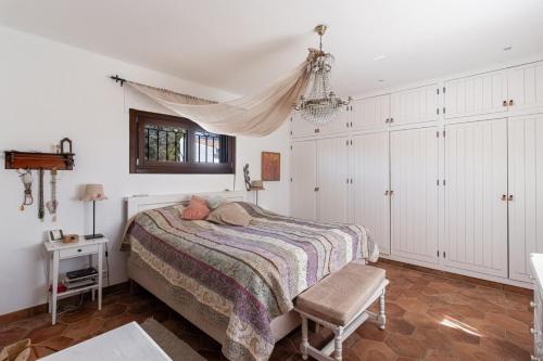 a bedroom with a bed and a chair in it at villa larwik frigiliana in Frigiliana