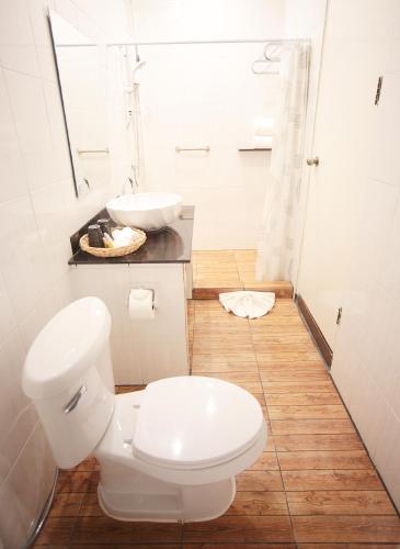 a white bathroom with a toilet and a sink at The Myth - Sud Sathorn in Bangkok