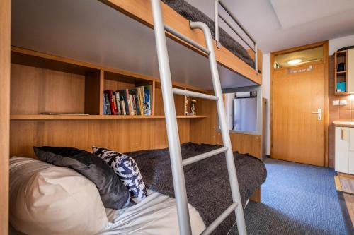 a bunk bed in a tiny house with a ladder at Riversound in Kranjska Gora