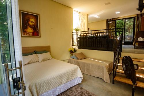 a bedroom with two beds and a stair case at Vivenda Serrana in Acarape