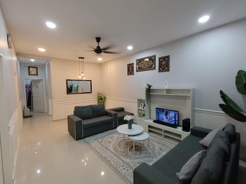 sala de estar con sofá y TV en JRC Homestay Kerteh, en Kampong Kemaman