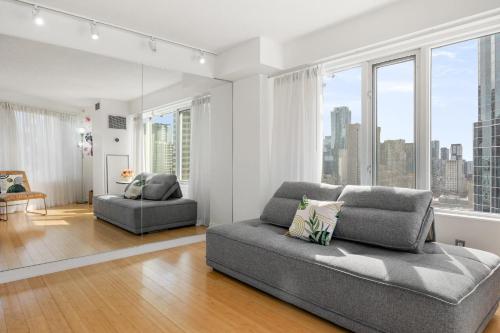 a living room with a couch and some windows at Modern 2-Bedroom Condo w Floor to Ceiling Windows in Toronto