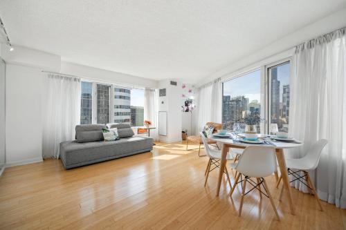 a living room with a couch and a table with chairs at Modern 2-Bedroom Condo w Floor to Ceiling Windows in Toronto