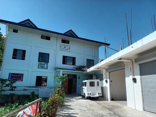 a white building with a van parked in front of it at The Soul Center in Batuan