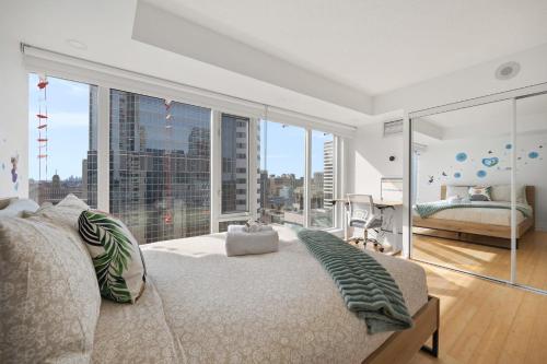 a bedroom with a bed and a large window at Modern 2-Bedroom Condo w Floor to Ceiling Windows in Toronto