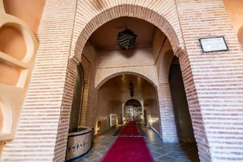 an empty hallway with a red carpet in a building at Kasbah Hotel Xaluca Arfoud in Erfoud
