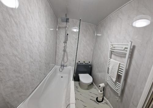 een badkamer met een douche, een toilet en een bad bij Cosy 2 BDR Flat with Free Parking close to Tower Bridge in Londen