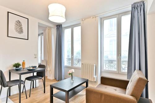 un salon avec un canapé et une table dans l'établissement Appartement proche Mairie 10ème arrondissement, à Paris