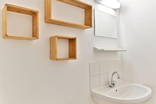 une salle de bain avec un lavabo et des miroirs au mur dans l'établissement Appartement proche Mairie 10ème arrondissement, à Paris