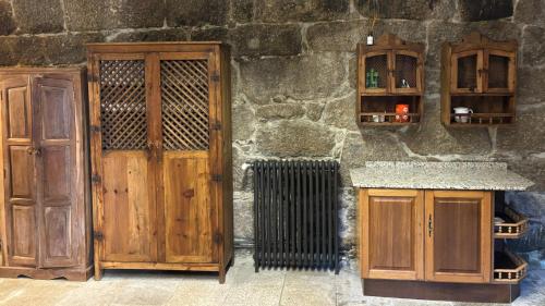 a stone wall with wooden doors and a counter at Pazo de San Pedro de Bembibre in Taboada