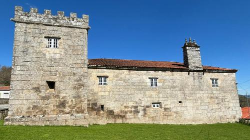 a large brick building with a chimney on top of it at Pazo de San Pedro de Bembibre in Taboada
