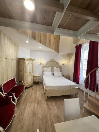 - une chambre avec un lit et deux chaises dans l'établissement Suite a Mezzanine dans l'Église du Couvent, à Narbonne