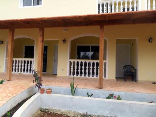 Casa ARCOIRIS في لاس غاليراس: شرفة منزل مع أعمدة خشبية