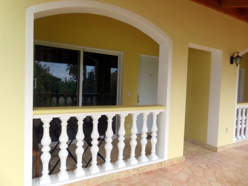 a balcony with a white railing and a window at Casa ARCOIRIS in Las Galeras