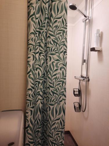 a shower curtain with a black and white pattern in a bathroom at KvarnDammens Bed & Breakfast in Vetlanda