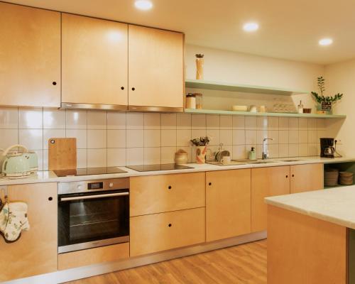 a kitchen with wooden cabinets and a stove top oven at Quinta da Quinhas in Vila Praia de Âncora