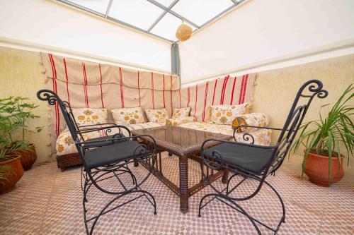 Dar houda في فاس: غرفة مع طاولة وكراسي وأريكة