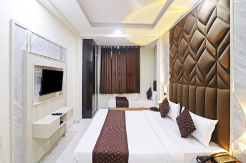 a hotel room with a large bed and a tv at Hotel Qubic Stay Near Delhi Airport in New Delhi