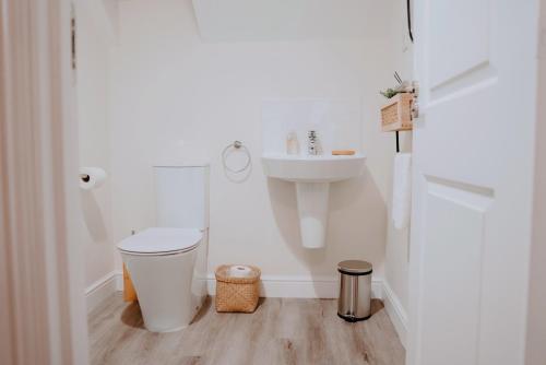 a white bathroom with a sink and a toilet at Leeds getaway with hot tub & gaming room in Wakefield