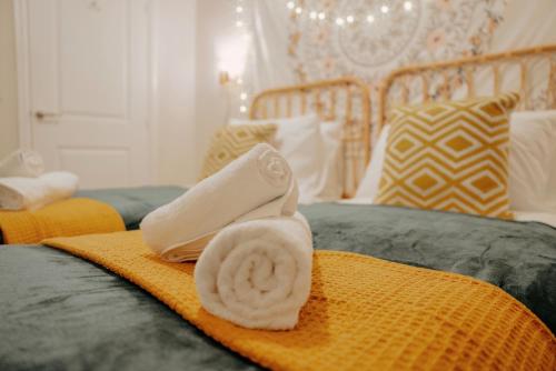 a white towel sitting on top of a bed at Leeds getaway with hot tub & gaming room in Wakefield