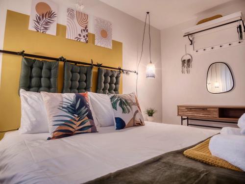 a bedroom with a large white bed with pillows at Leeds getaway with hot tub & gaming room in Wakefield