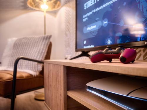 a living room with a tv and a table at Leeds getaway with hot tub & gaming room in Wakefield
