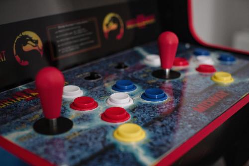 a close up of a game with red and yellow knobs at Leeds getaway with hot tub & gaming room in Wakefield