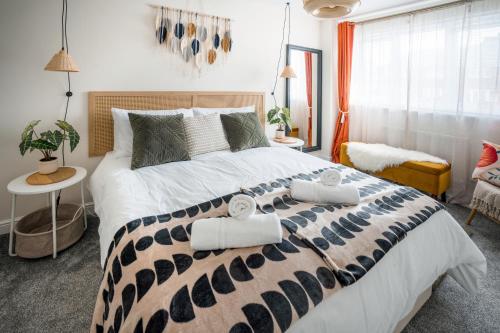 a bedroom with a large bed with towels on it at Leeds getaway with hot tub & gaming room in Wakefield