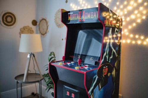 a video game machine in a room with lights at Leeds getaway with hot tub & gaming room in Wakefield