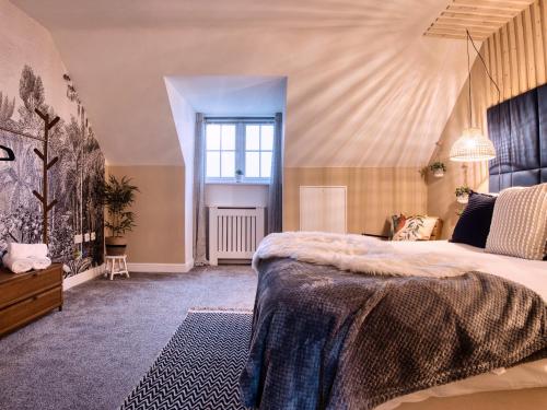 a bedroom with a large bed and a window at Leeds getaway with hot tub & gaming room in Wakefield