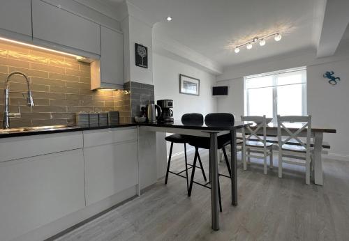 a kitchen with a table and chairs in a room at Belle Vue in Sandown