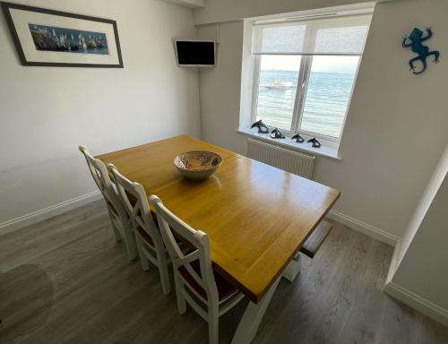 a dining room with a wooden table and chairs at Belle Vue in Sandown