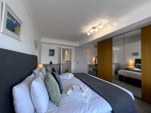 a bedroom with a large white bed with pillows at Belle Vue in Sandown