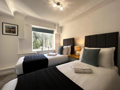 a bedroom with two beds and a window at Belle Vue in Sandown