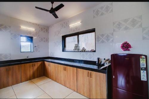 a kitchen with a refrigerator and a ceiling fan at OCEAN CREST LUXURY VILLA Mahabaleshwar in Mahabaleshwar