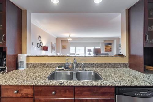 eine Küche mit einem Waschbecken und einem großen Spiegel in der Unterkunft Lovely Waterfront Apt #807 with AC in Halifax