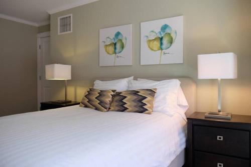 a bedroom with a white bed and two lamps at Deluxe Downtown Apt #404 with AC in Halifax