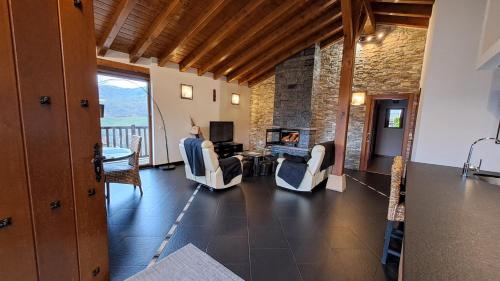 a living room with a fireplace and a table and chairs at Casa Angiz etxea in Sumbilla