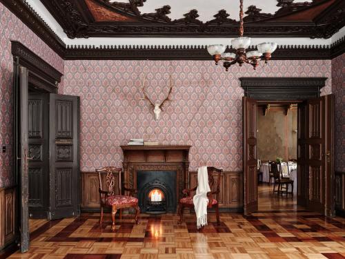 a living room with a fireplace and pink wallpaper at Pałac Potockich w Będlewie in Będlewo