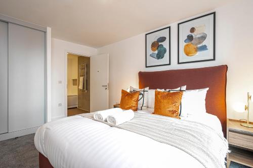 um quarto com uma grande cama branca com almofadas laranja em Monk Bridge Viaduct em Leeds