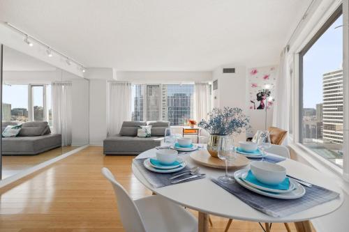 a white dining room with a white table and chairs at Modern 2-Bedroom Condo w Floor to Ceiling Windows in Toronto