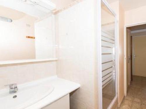 une salle de bain blanche avec un lavabo et un miroir dans l'établissement Cassis - Appartement T3 Climatisé et vue mer, à Cassis