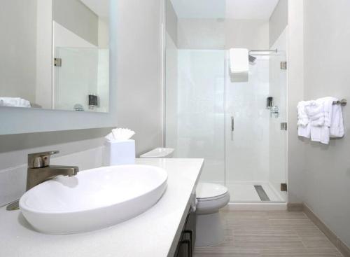 a white bathroom with a sink and a toilet at Private Downtown Apartment With City View in Raleigh