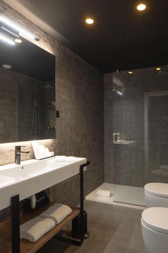 a bathroom with a sink and a shower and a toilet at Hotel Tayko Bilbao in Bilbao