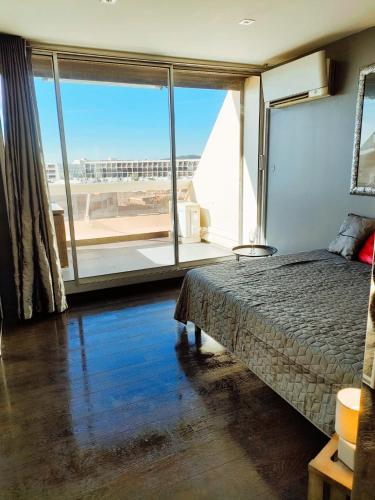 une chambre avec un lit et une grande fenêtre dans l'établissement Village Naturiste Cap d'Agde Le Vip, au Cap d'Agde