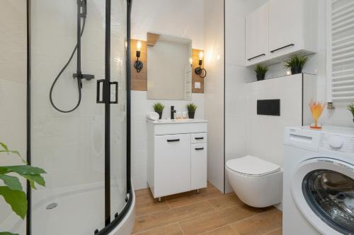 a white bathroom with a shower and a toilet at Modern Studio Wróblewskiego with Balcony and Free Parking by Renters in Łódź