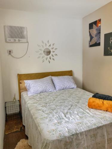 um quarto com uma cama e uma ventoinha na parede em C-house em Ubatuba