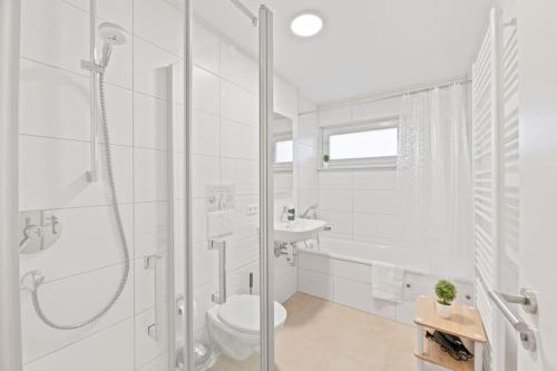 een badkamer met een douche, een toilet en een wastafel bij W01 Große Wohnung für Teams in Wendlingen am Neckar
