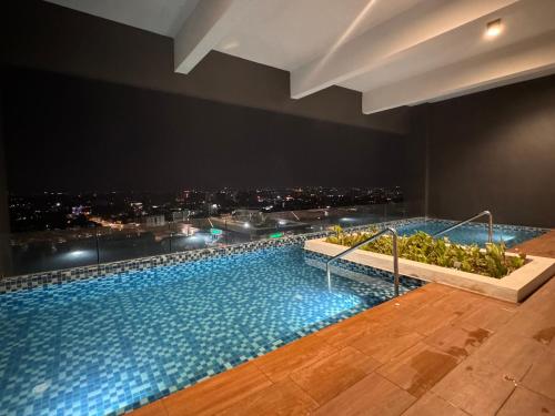 a swimming pool with a view of a city at night at Ipoh Horizon Skypool Town Suites 4-11pax by IWH Suites in Ipoh