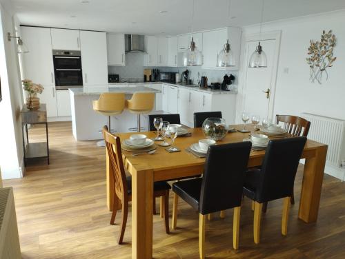 a kitchen and dining room with a wooden table and chairs at Old Castle in Pembrokeshire
